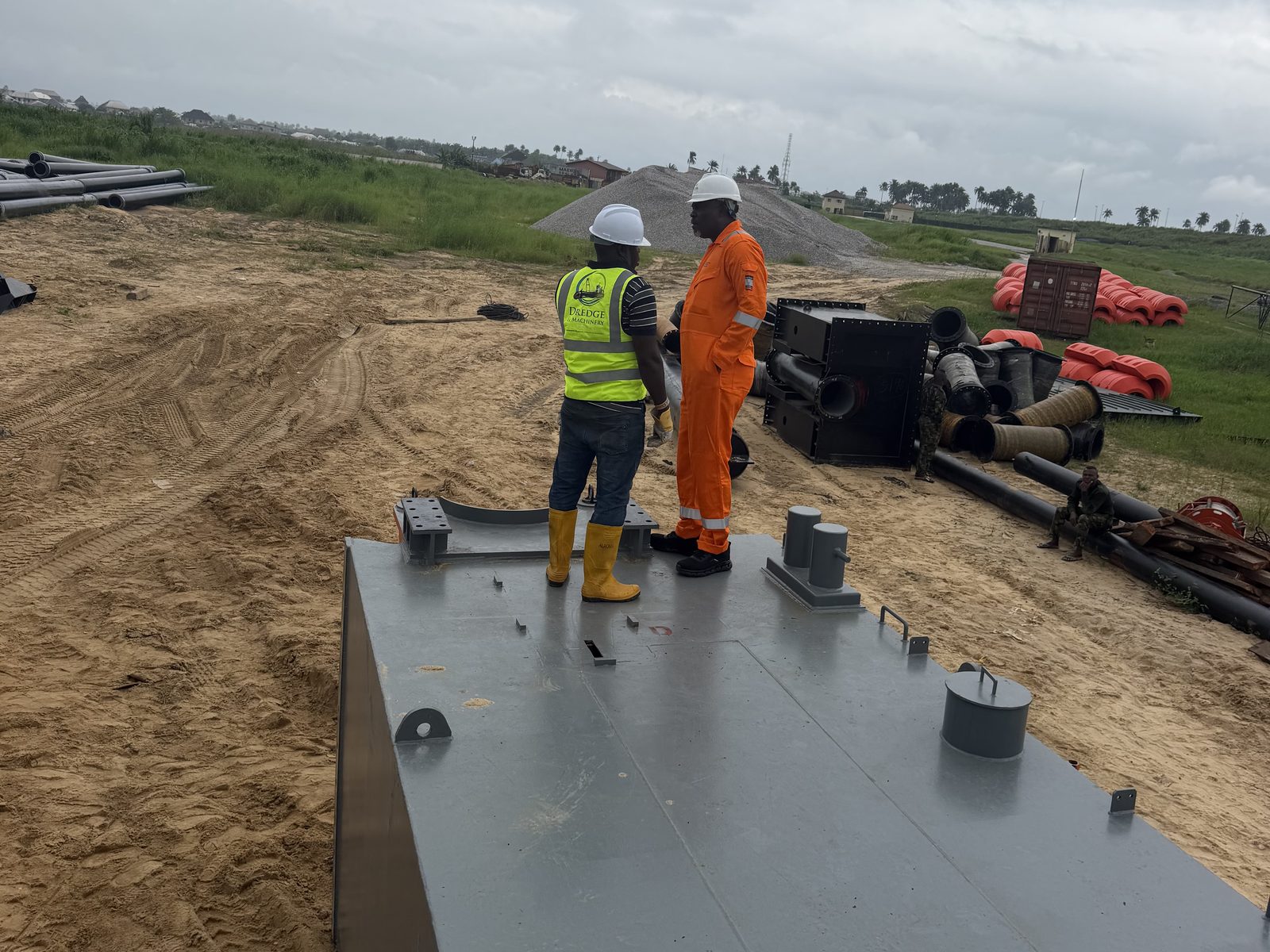 New dredger hull under inspection on the riverbank