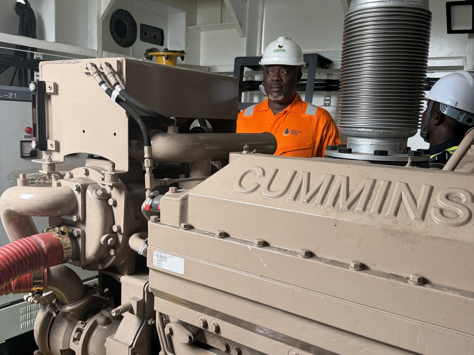 Engineers with the Cummins main engine aboard a dredger